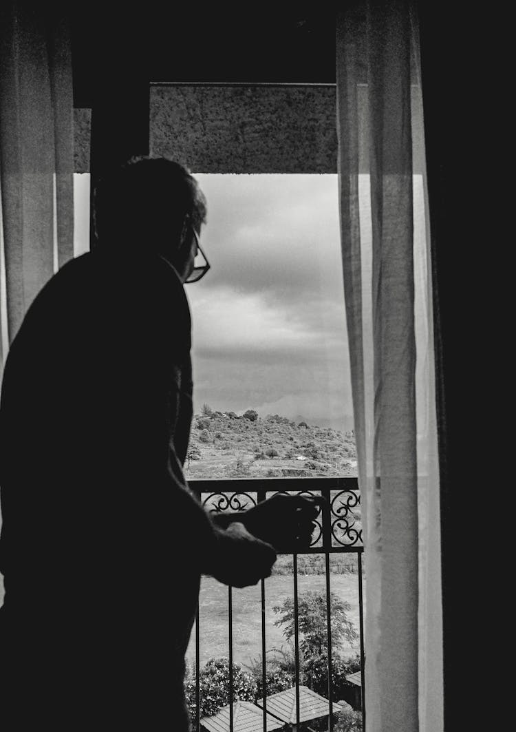 Silhouette Of A Man Looking Out The Window