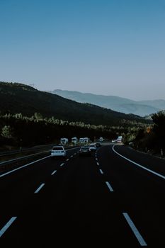A serene highway view with cars driving through picturesque mountain scenery at dusk.