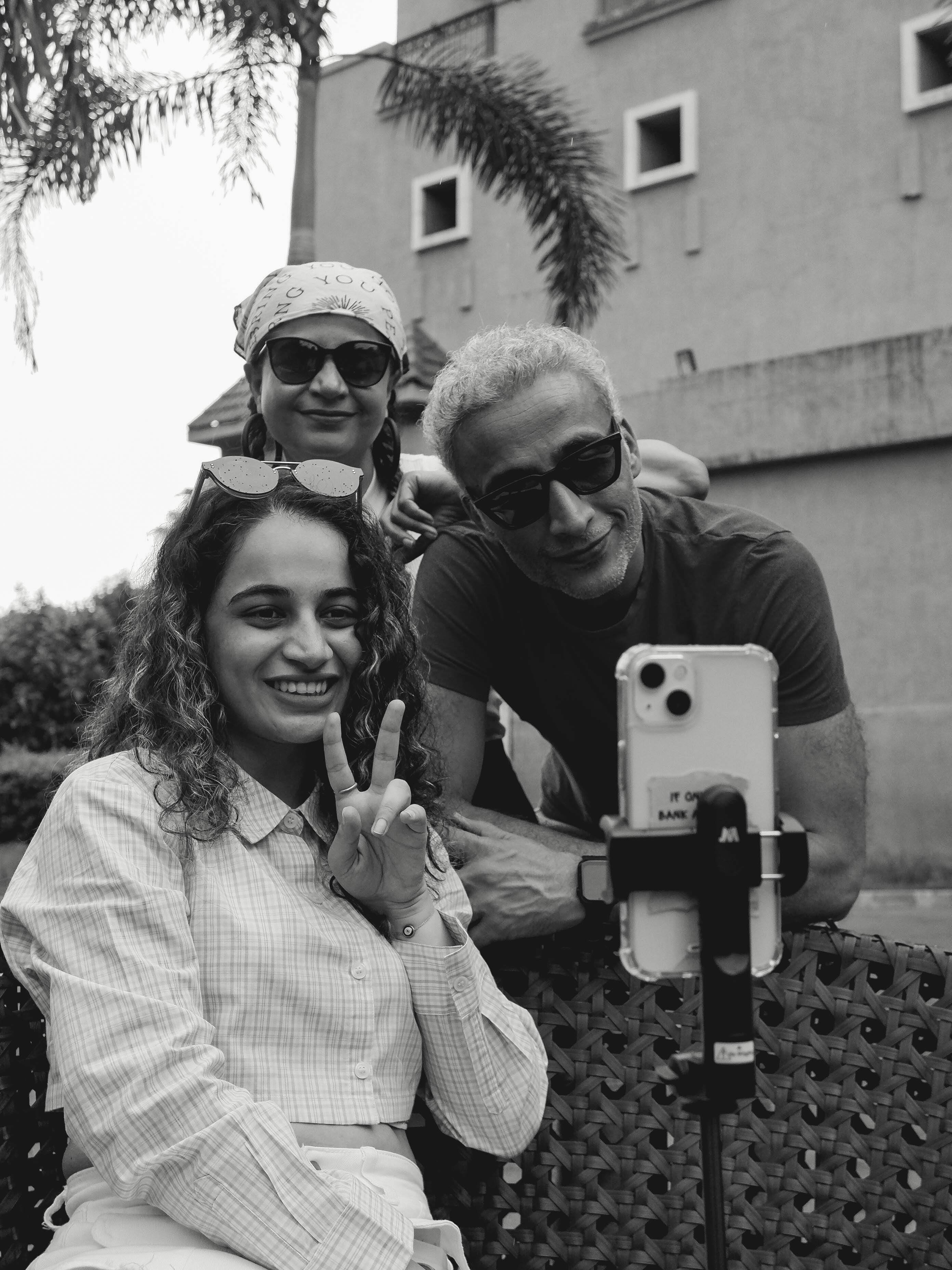 Three people posing for a black and white selfie outdoors, smiling and having fun.