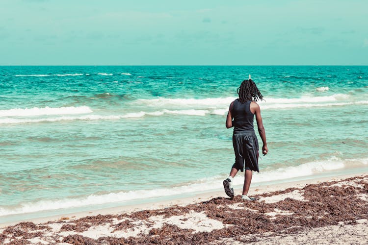 A Man Walking At The Beach 