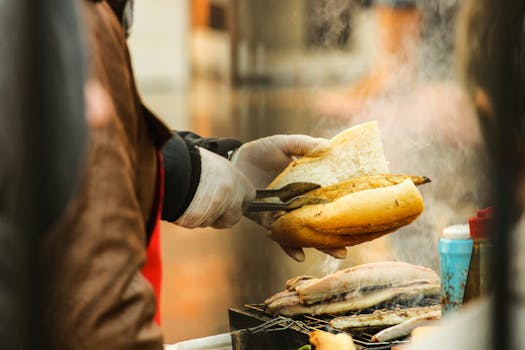 Close-up of a street vendor grilling a sandwich, smoke rising, capturing the essence of street food.