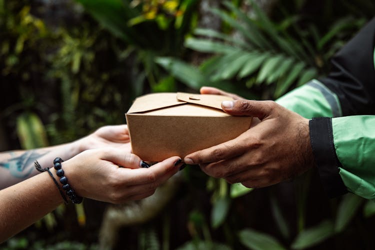 Close Up Of A Person Handing Over A Package