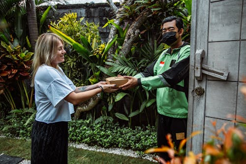 A Woman Receiving a Small Box from Delivery Man