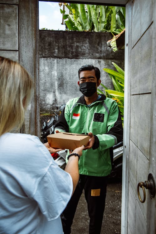 A Man in Green Jacket Delivering Food