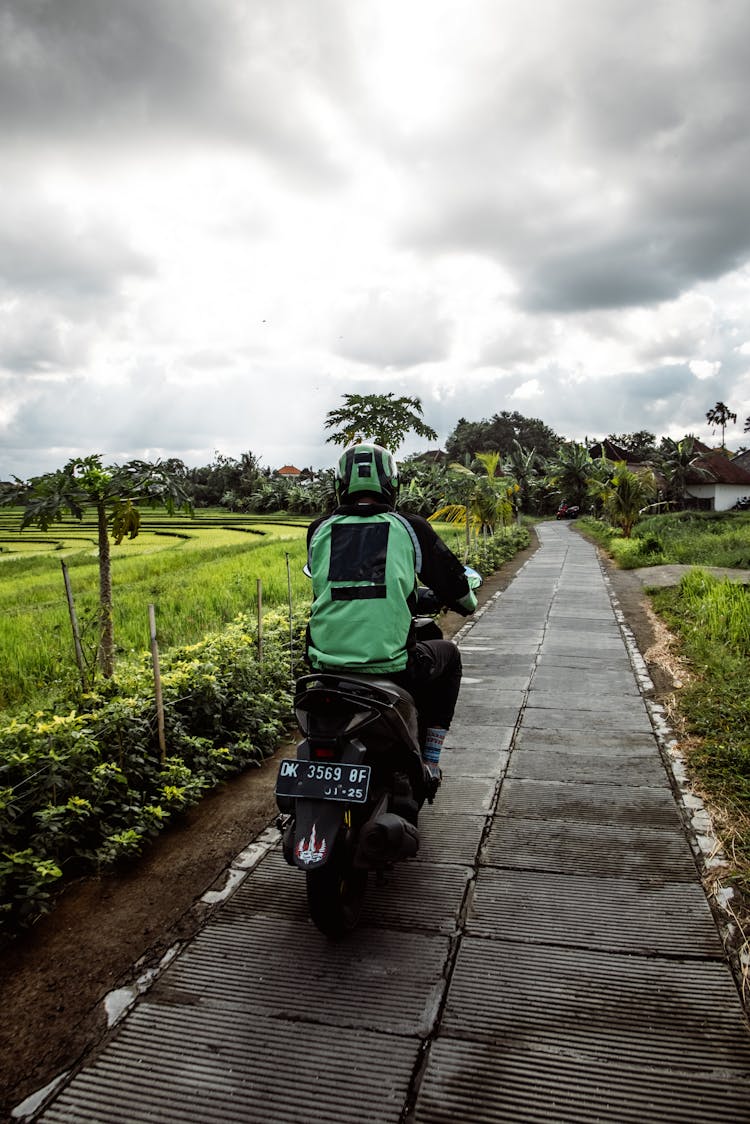 Back View Of A Person Riding A Scooter 