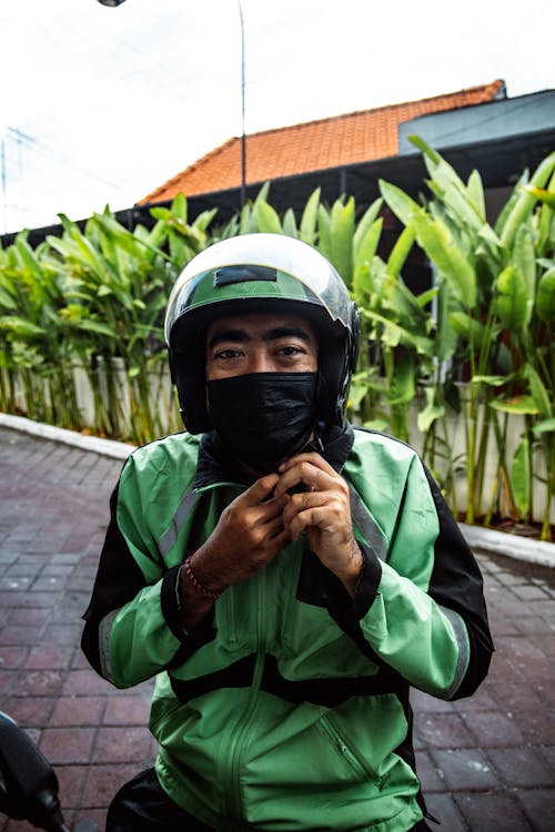 Man in Green Jacket Wearing a Helmet