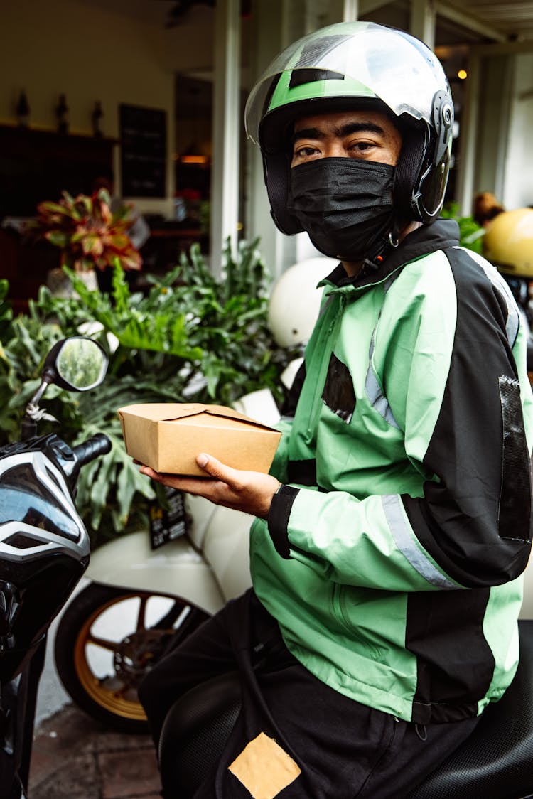 A Biker Holding  A Box Of Food