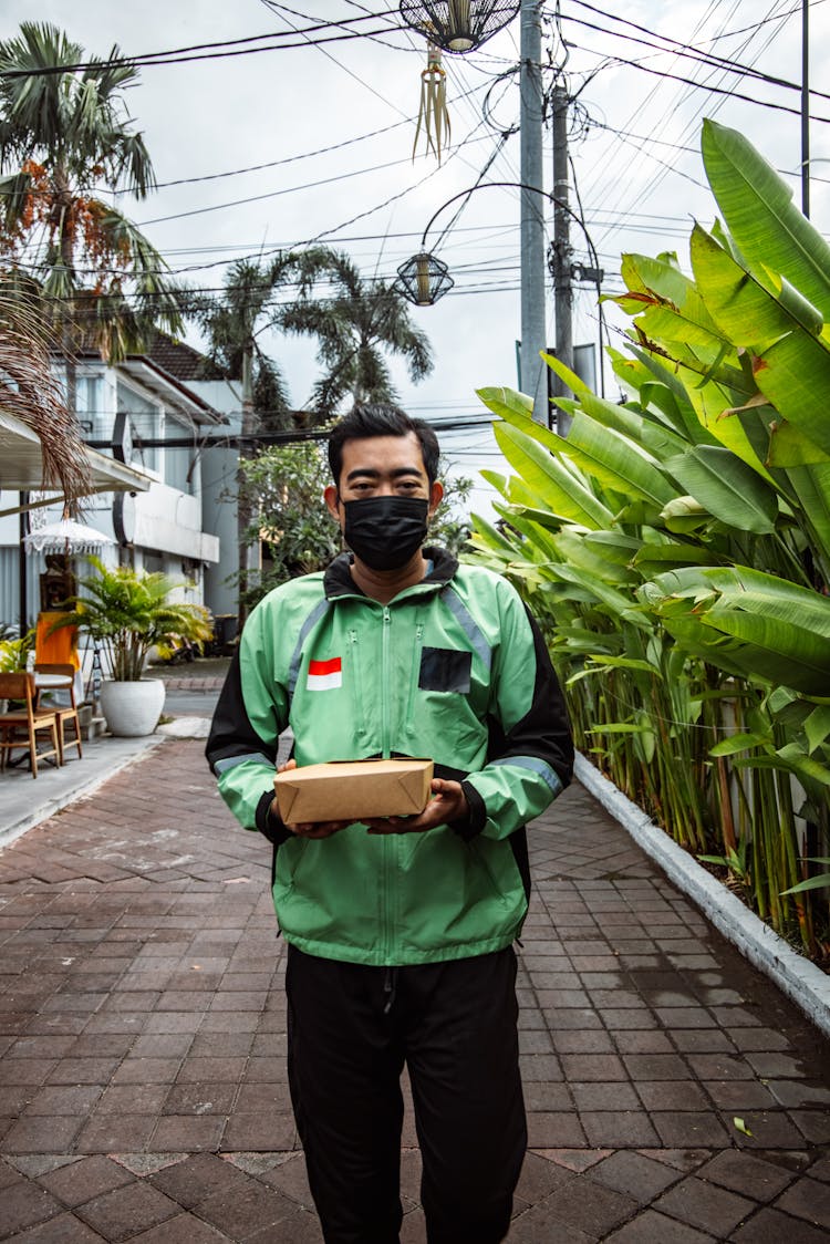 A Deliveryman Holding A Box Of Food