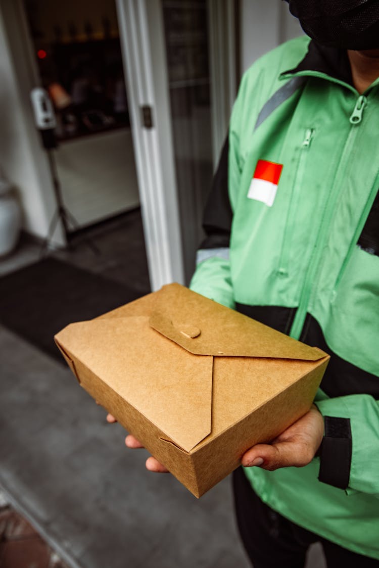 A Person Holding A Takeout Meal