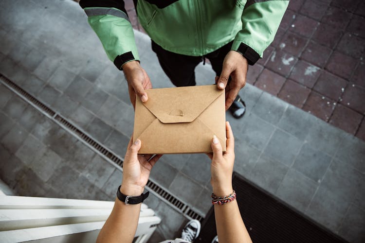 Man And Woman Hands Holding Envelope