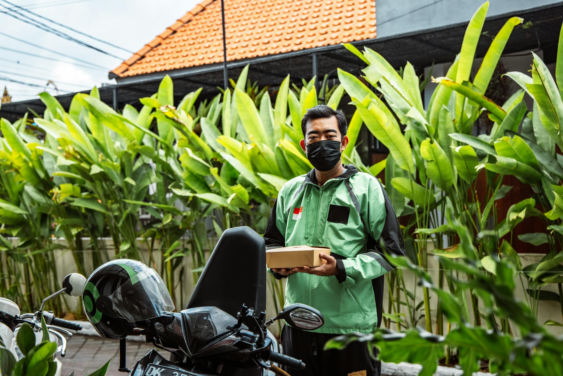 Delivery Man Holding Takeout Box Standing on Sidewalk