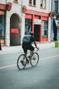 Man in Black T-shirt Riding Bicycle on Road