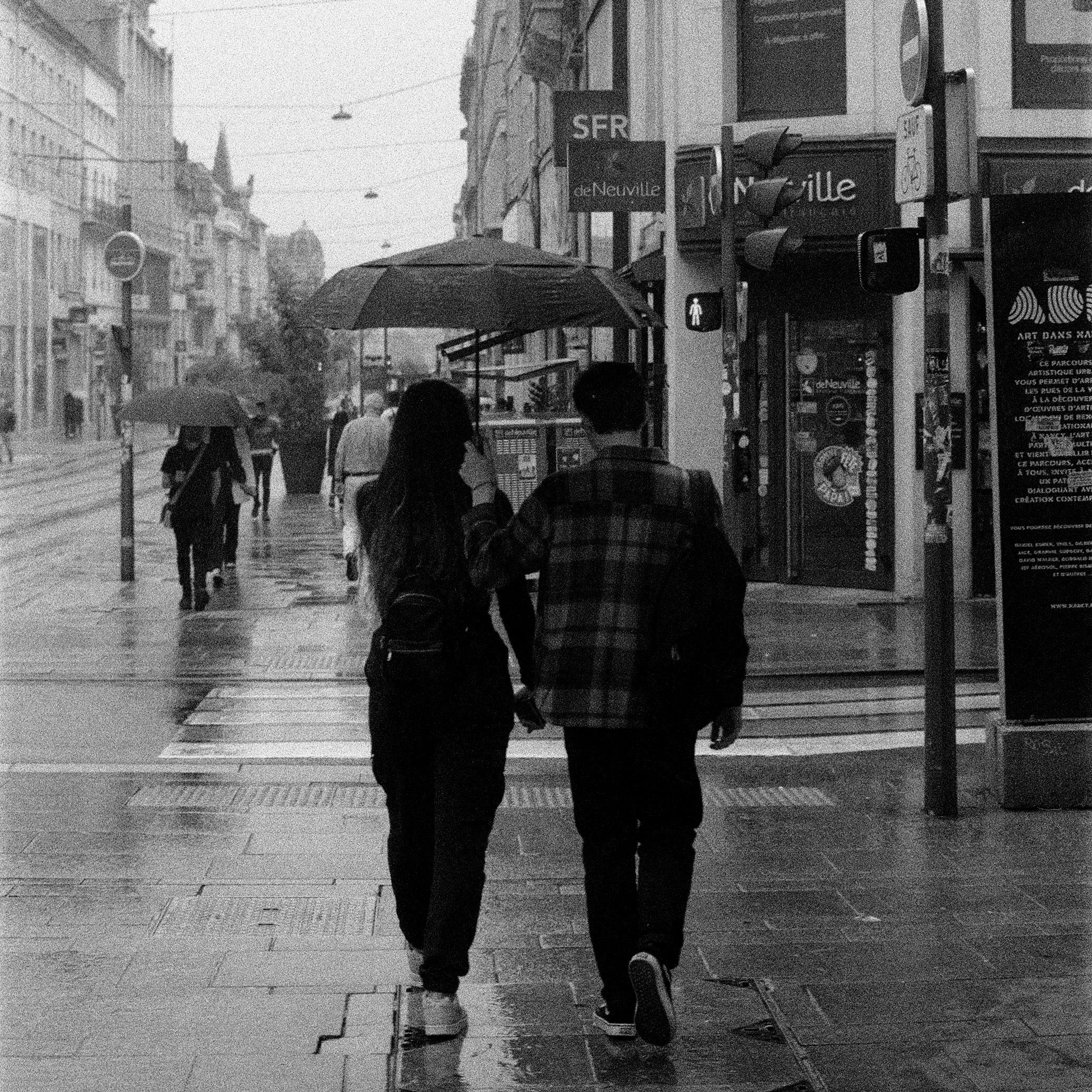 Monochrome Shot of a Couple Walking while Raining · Free Stock Photo