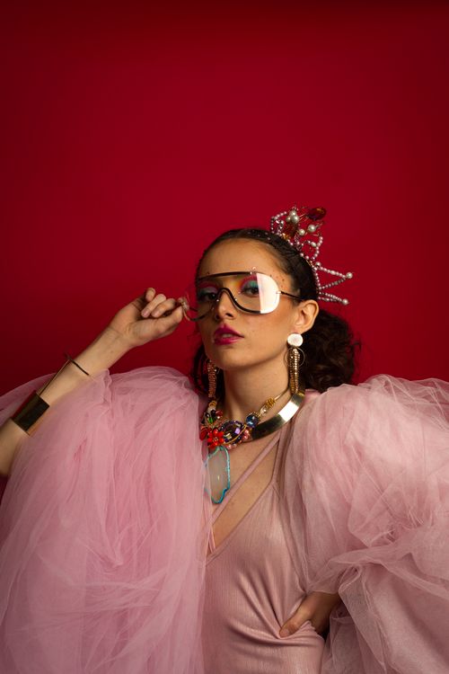 Free Fashionable woman posing with accessories against a vibrant red background in Celaya, Mexico. Stock Photo