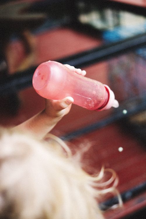 Free A child's hand holding a pink bottle, emphasizing texture and detail in a close-up shot. Stock Photo