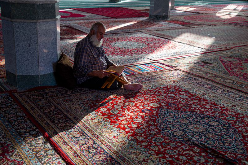 Seorang jemaah membaca al-Quran dengan khusyuk di dalam masjid