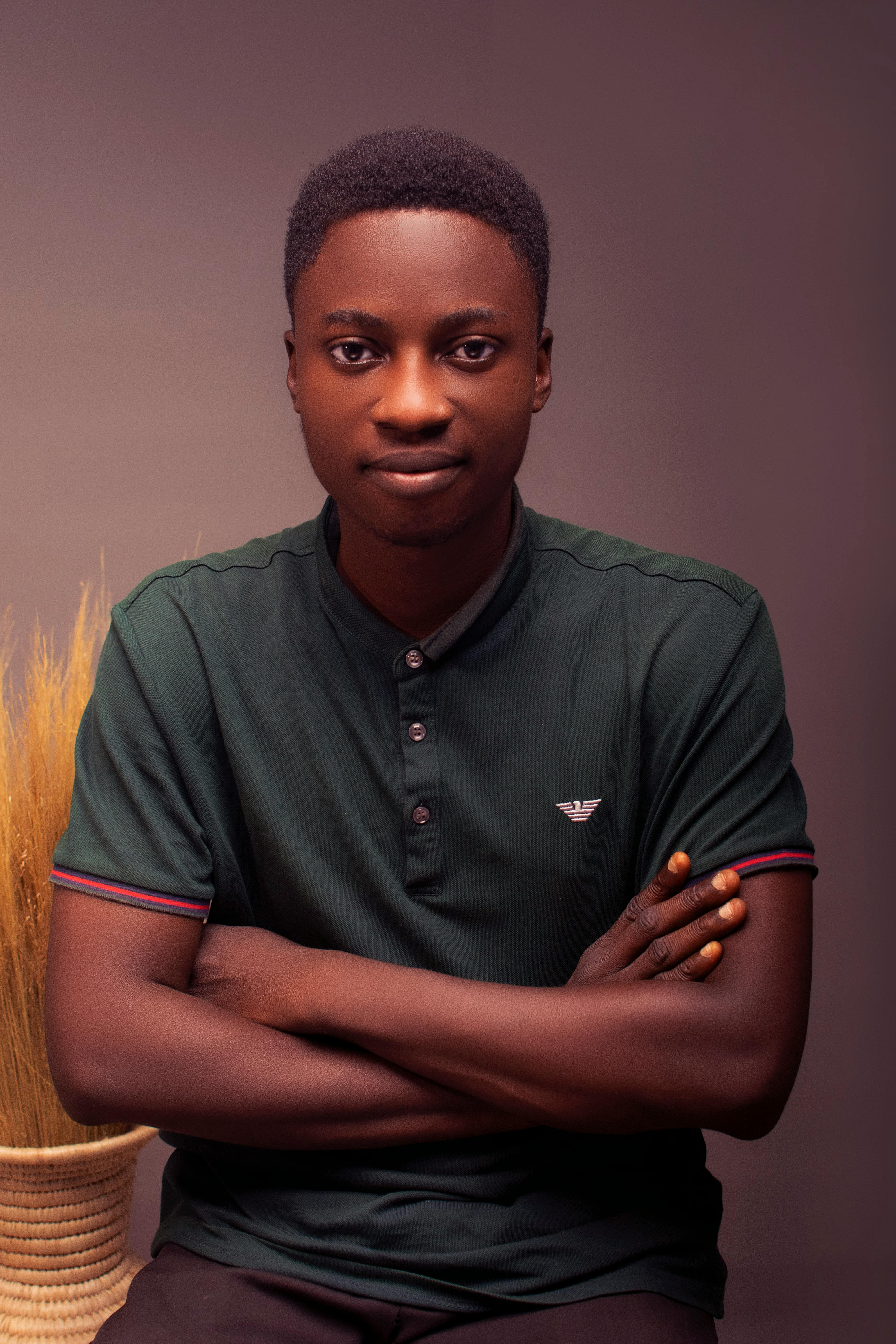 Portrait of a young man with crossed arms, exuding confidence and style.