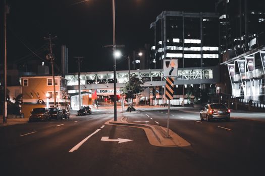 A Car Driving Down a Road at Night Time