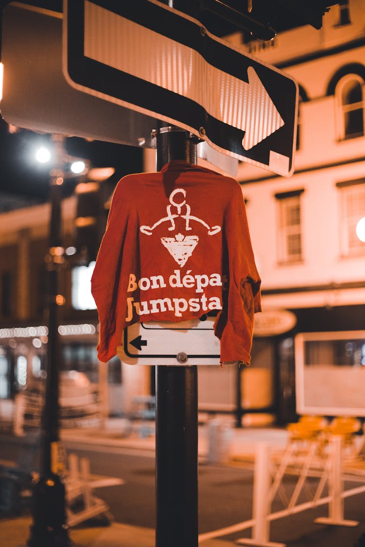 A Red Long Sleeve Shirt Hanging On A Street Metal Post Signage