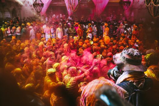 A lively crowd celebrates Holi with colorful powders in India.