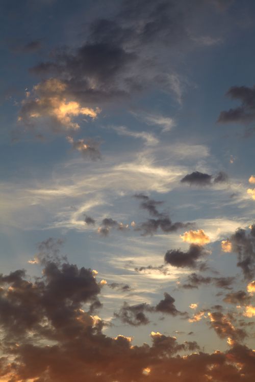 Free Dynamic clouds with hues of orange and blue during a breathtaking sunset. Stock Photo