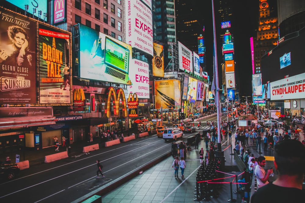 Times Square de noche con marquesinas de Broadway y luces de neón