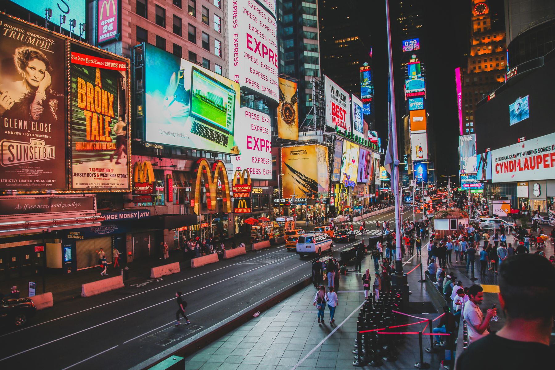 Illuminated billboards at night in a busy city square