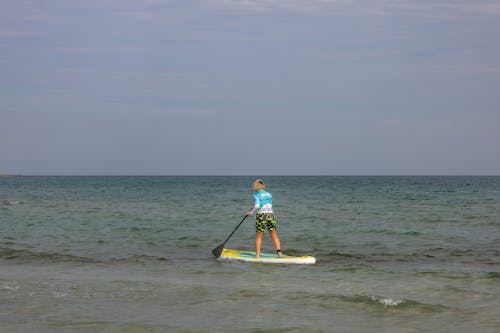 A Person Paddle Boarding on the Sea