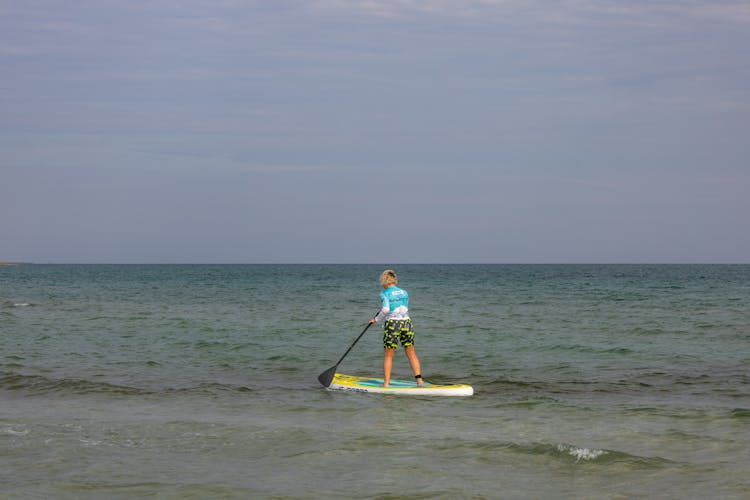 A Person Paddle Boarding On The Sea