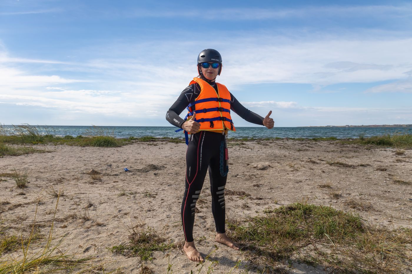 Water-sports participant wearing a wetsuit, life vest, and safety equipment