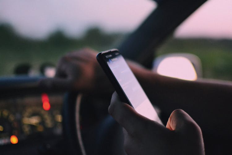 A Person Inside A Car Using A Cellphone