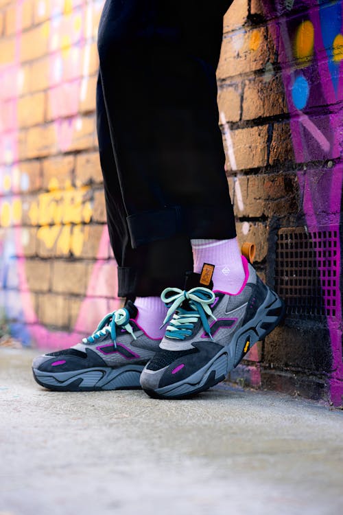 Close up of Person Shoes near Colorful Wall