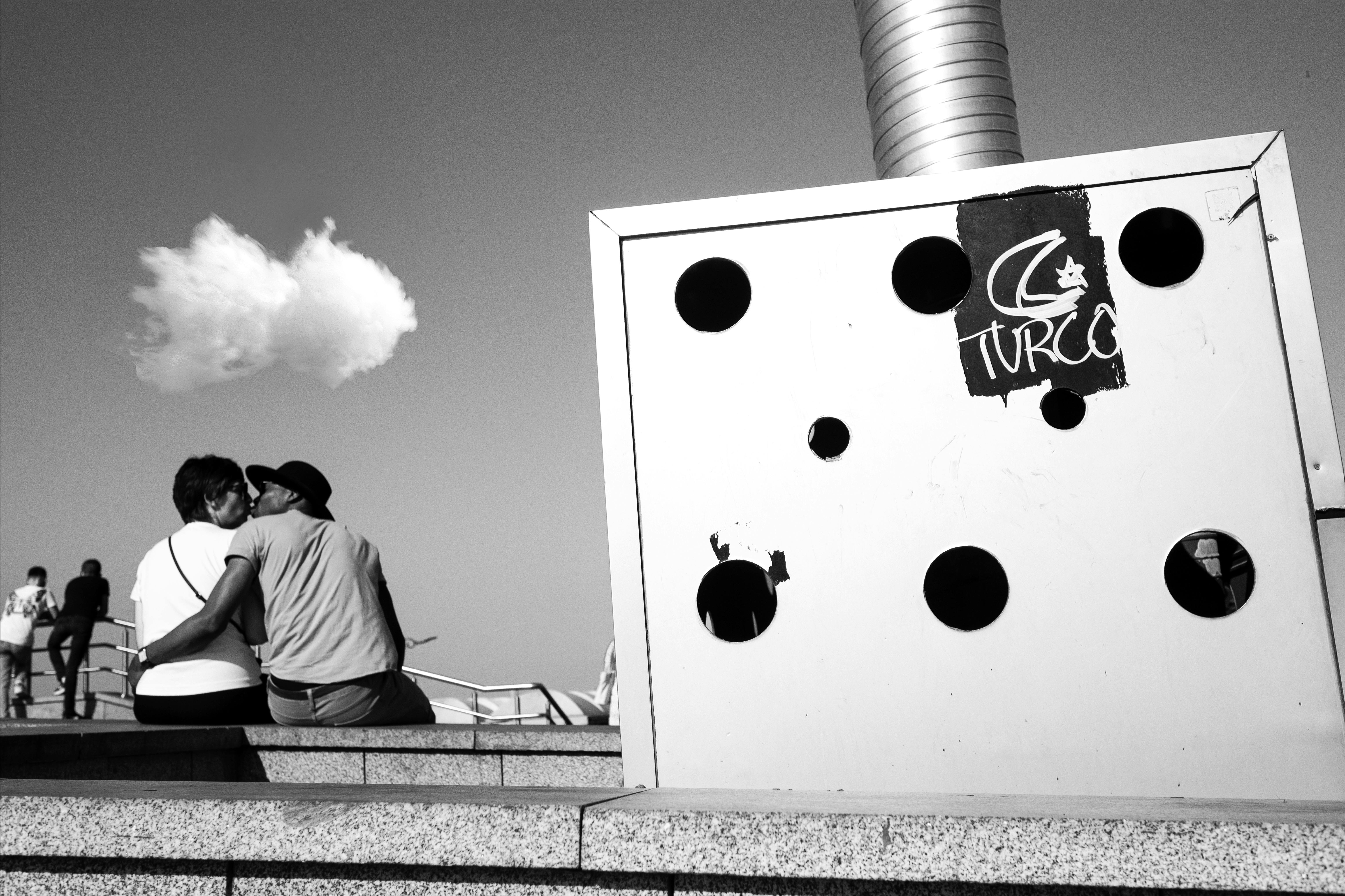 Couple embracing on İstanbul street, capturing love in black and white.