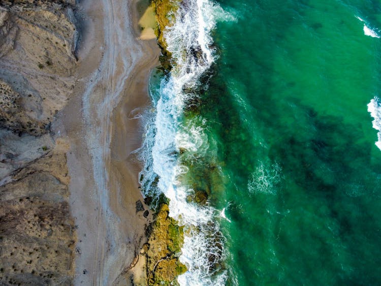 Aerial Shot Of Waves Crashing The Beach