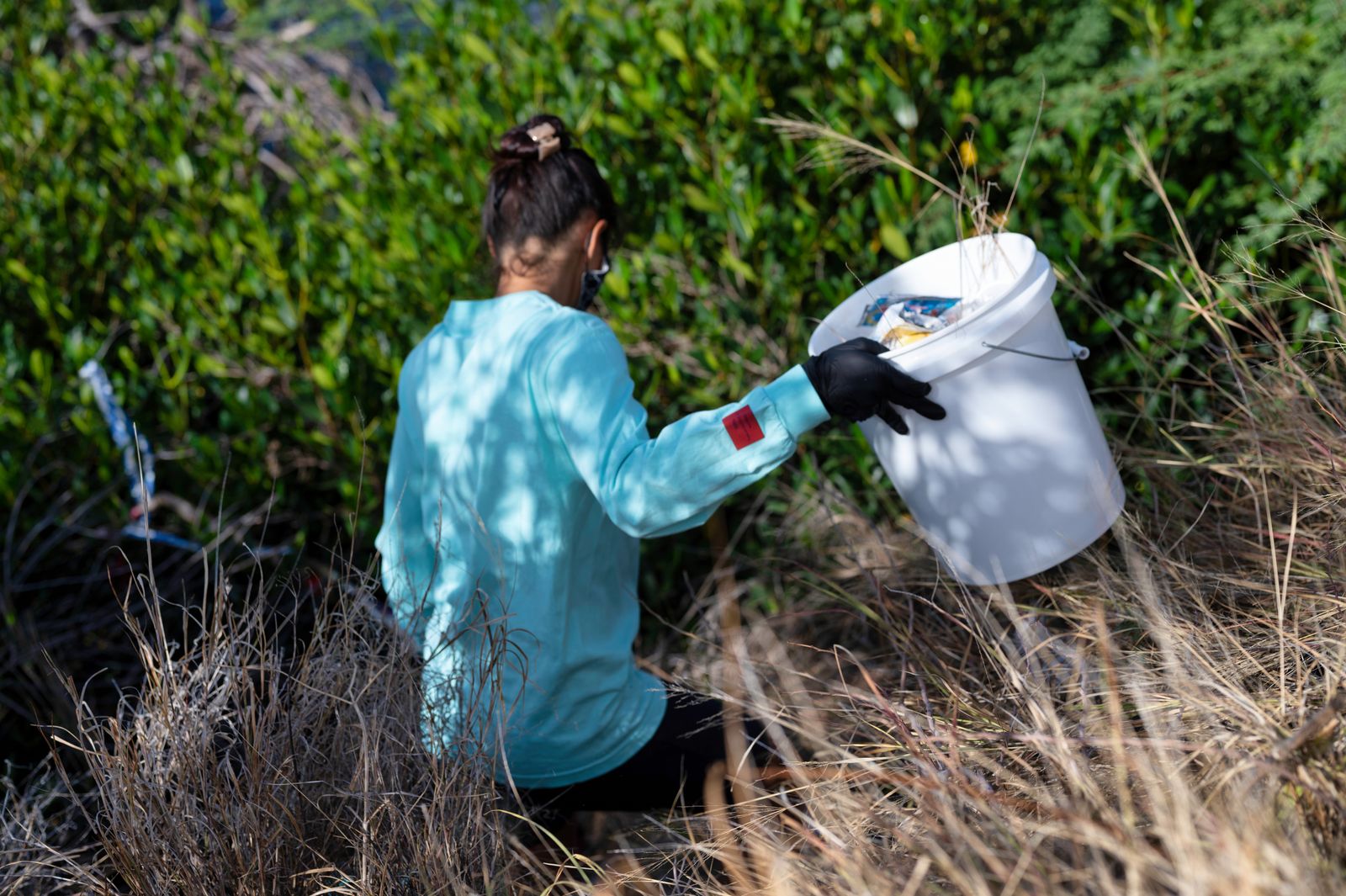 Volunteer collecting trash in a natural setting.
