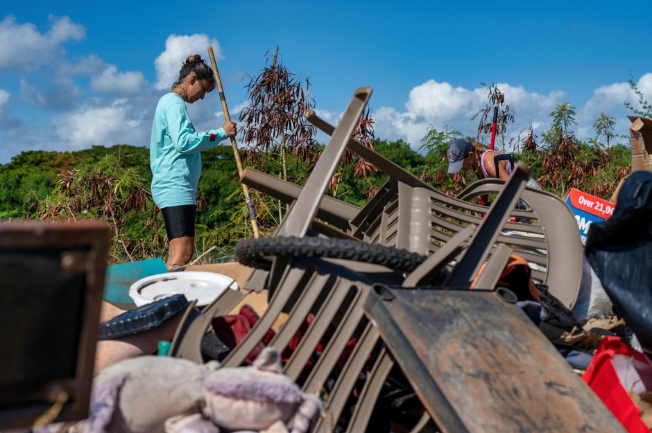 Photo by Alfo Medeiros Two women cleaning up a pile of garbage at an outdoor site in Hawaii. Eco-friendly activity.