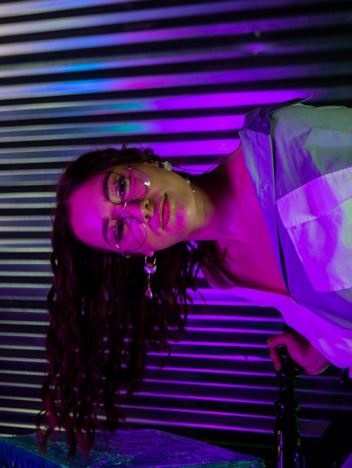 Free A creative portrait of a woman with neon lighting, showcasing modern fashion and expression. Stock Photo