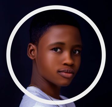 Charming portrait of a young boy framed by a circle with a black background.