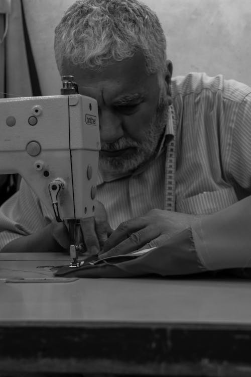 Man in Striped Shirt Using Sewing Machine