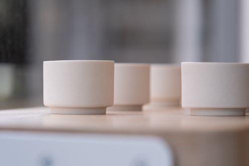 Free A still life of simple ceramic cups on a wooden table with a soft blurred background. Stock Photo