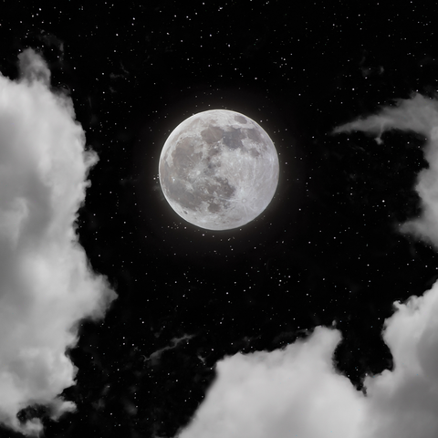 Full moon between clouds in a starry night sky — Dennis Ariel on Pexels