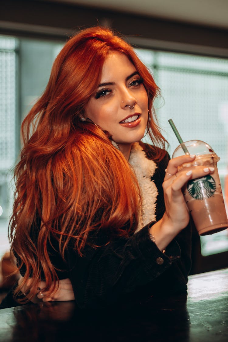 A Woman Holding A Starbucks Drink