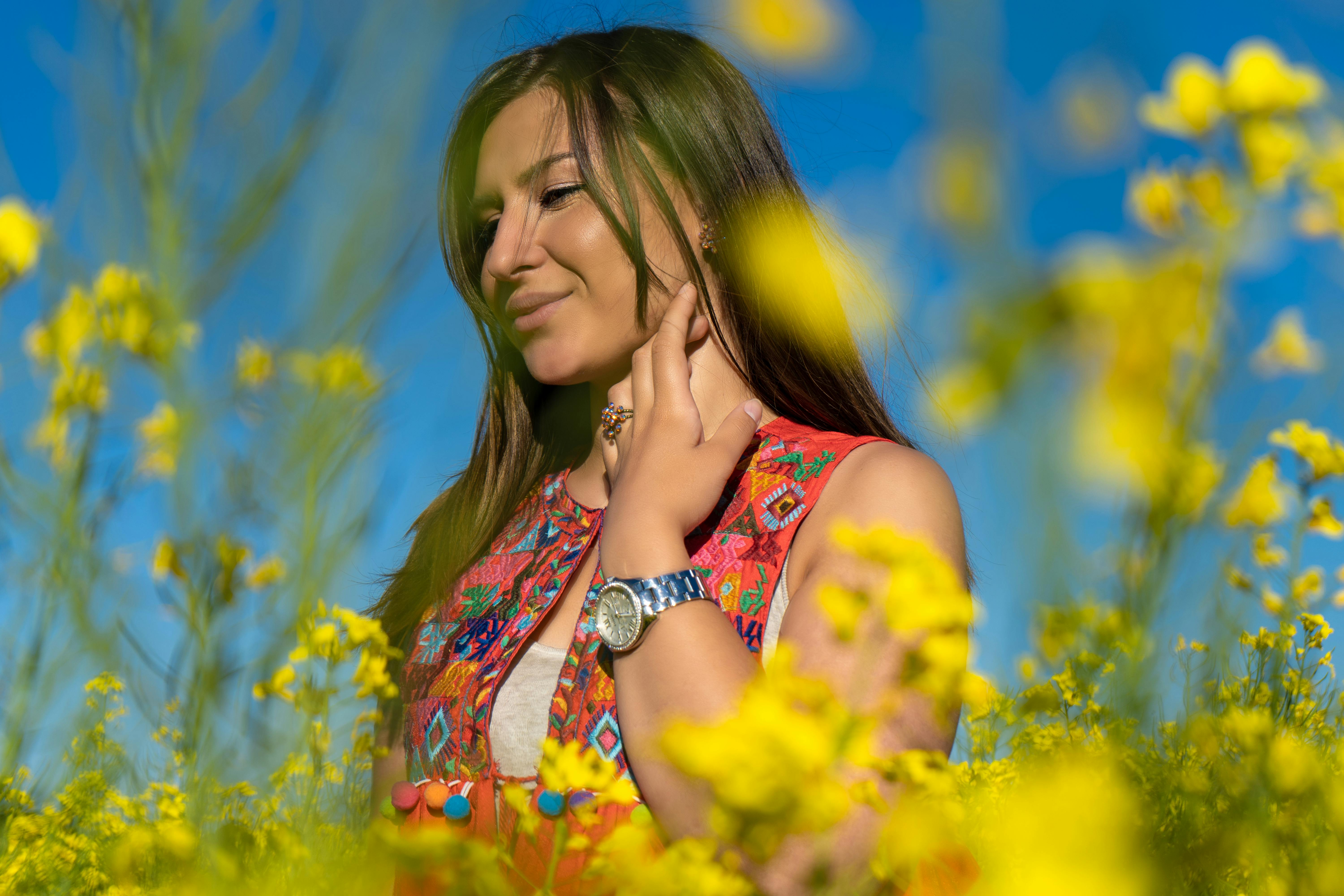 Woman Wearing Gray Watch Standing on a Bed of Yellow Flowers · Free Stock Photo