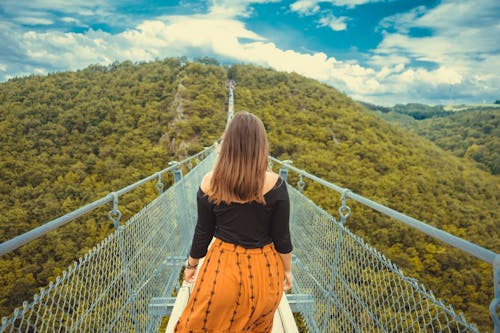 Free Photo of Woman Walking on a Canopy Walkway. Stock Photo