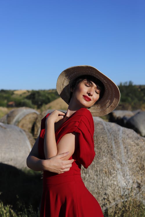 Model Posing in Red Dress and Hat