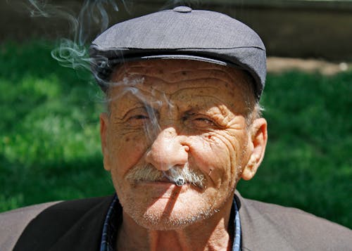 Close-Up Shot of an Elderly Man Smoking Cigarette