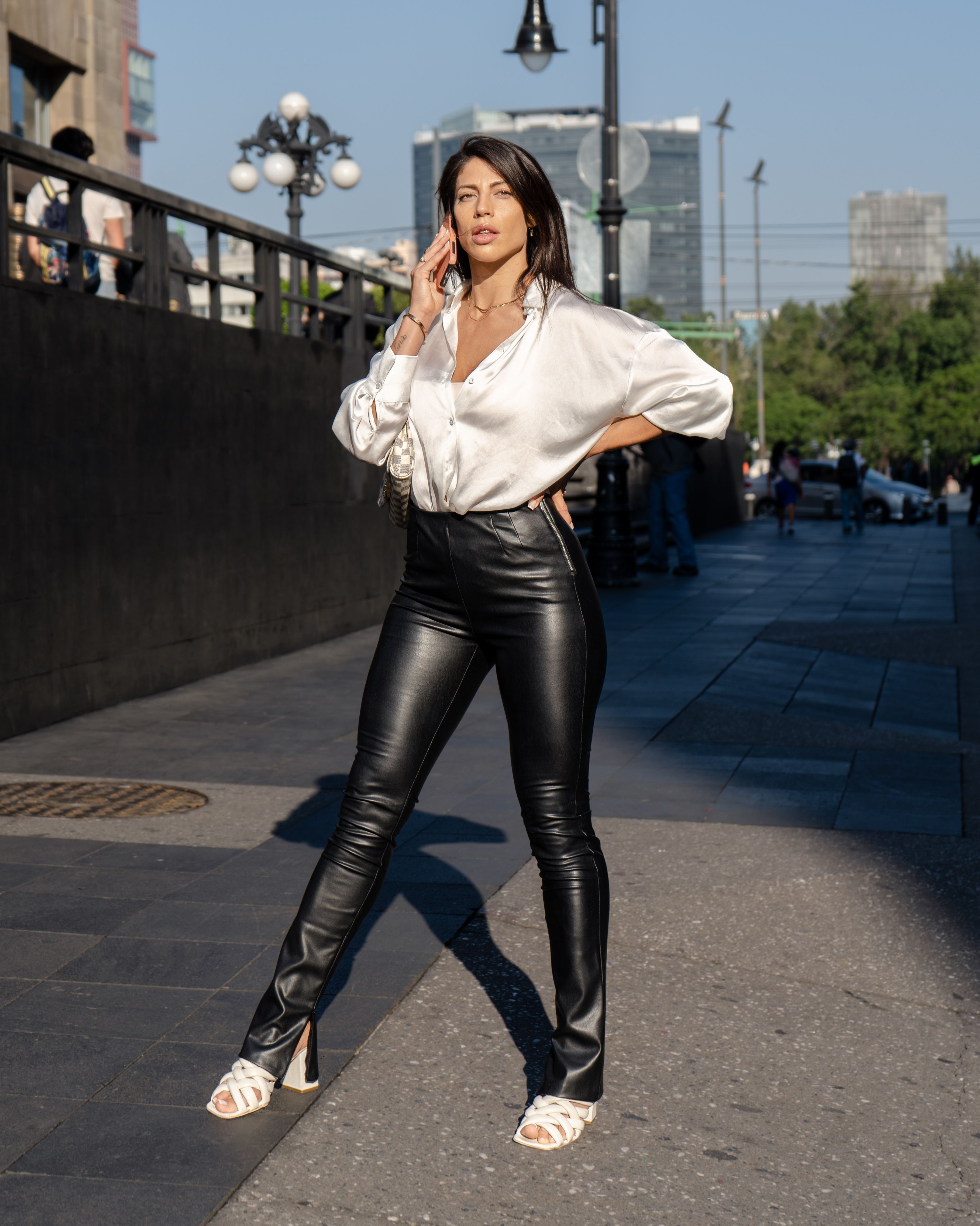 woman in ivory silk blouse and black leather trousers