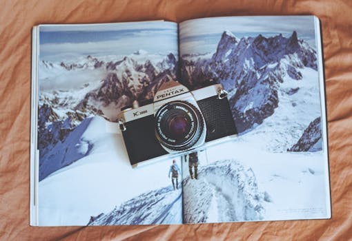Pentax K1000 analog camera positioned on a mountain photography magazine.