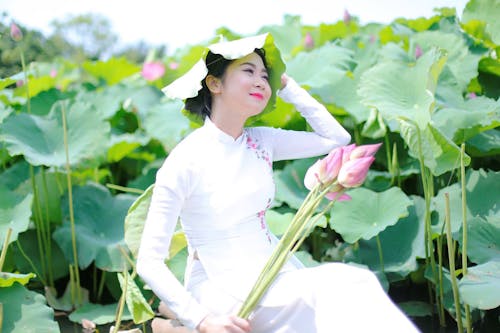Gratis lagerfoto af asiatisk kvinde, blomster, grønne blade