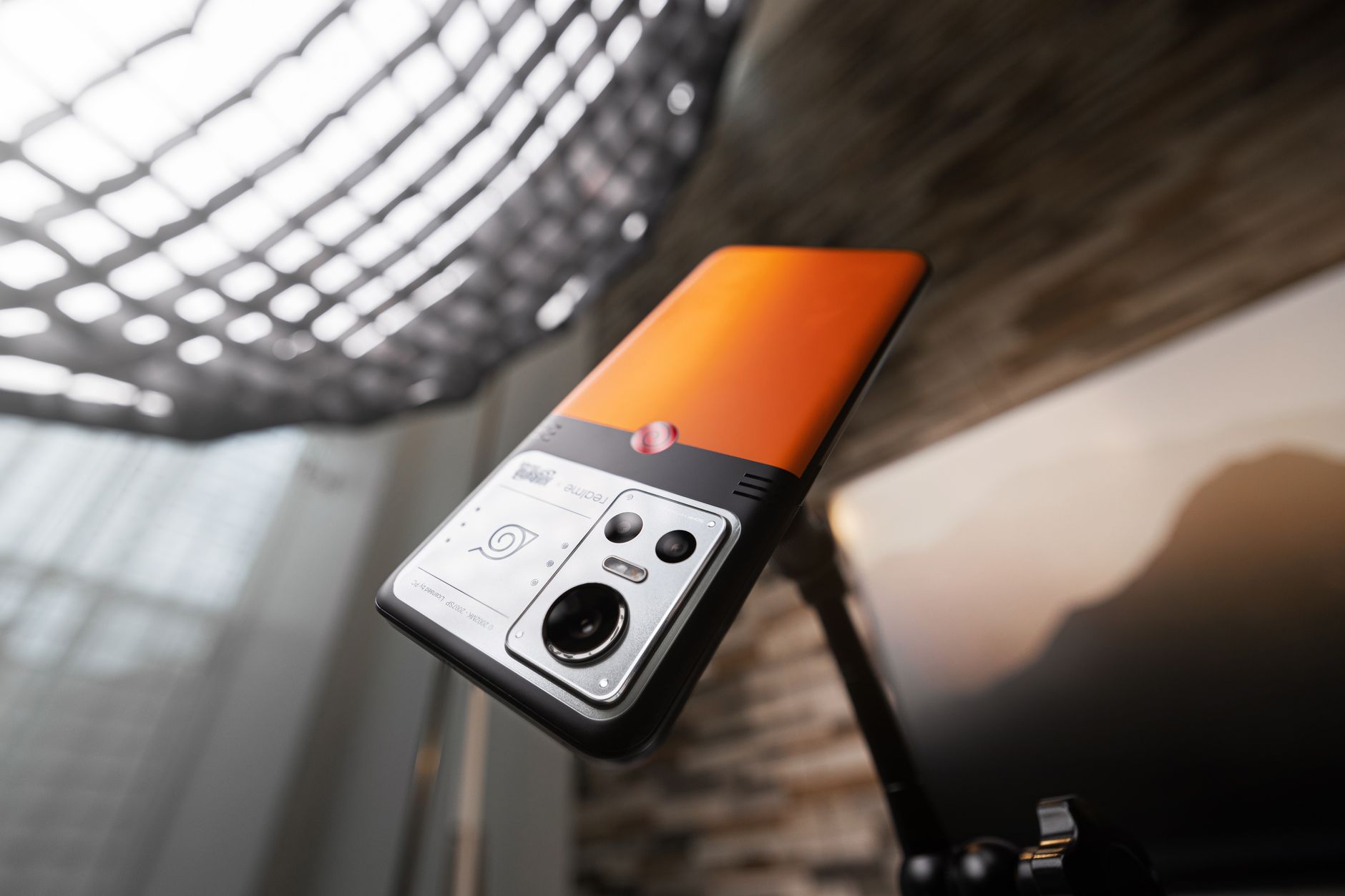 Best Phone for Reaction Video Creators: Top Picks Sleek orange smartphone mounted on a tripod, showcasing advanced camera features.